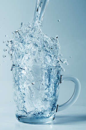 Water pouring into a transparent cup