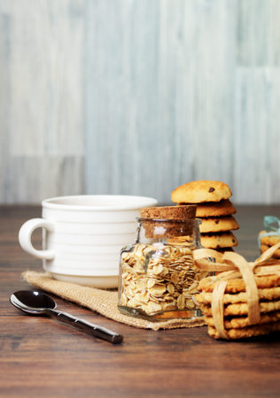 A jar of oats and cookis with ribbons with a cupの写真素材