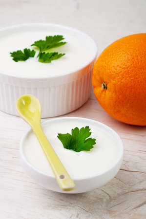 An orange and a spoon with two white bowlsの写真素材