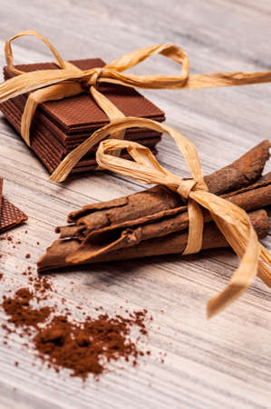 Cinnamon sticks and chocolate pieces tied with same color bowsの写真素材