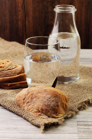 Some bread and water in a glassの写真素材