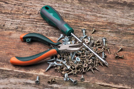 A screwdriver with screws and Linesmans pliersのeditorial素材