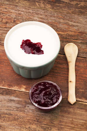 A bowl of cream and a bowl of jam with a spoonの写真素材