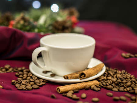 A white cup with cinnamon and coffee beansの写真素材