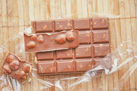 Image of openned pack of milk chocolate with nutsの写真素材