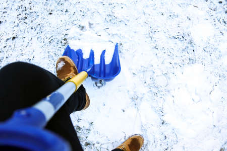 Man worker in uniform ,shoveling snowの写真素材