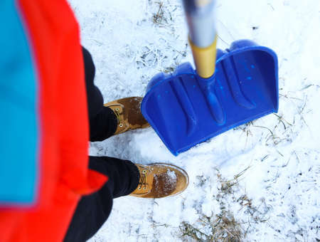 Man worker in uniform ,shoveling snowの写真素材