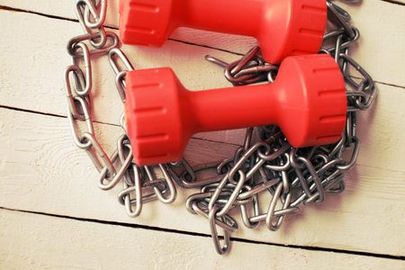 Image of chain and red dumbbells on the table