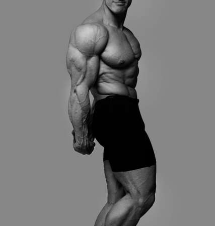 Portrait of muscle man posing in grey backgroundの写真素材