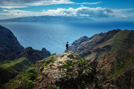 Man standing on the hill against background of the beautiful mountain landscape