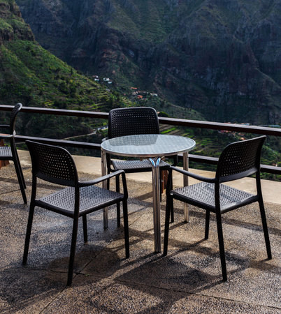 Calm recreation place with round table and chairs and beautiful view on mountainsの写真素材