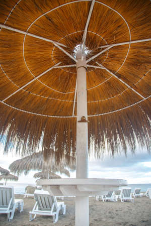 Sunshade and sunbeds on the beacj near the waterの写真素材