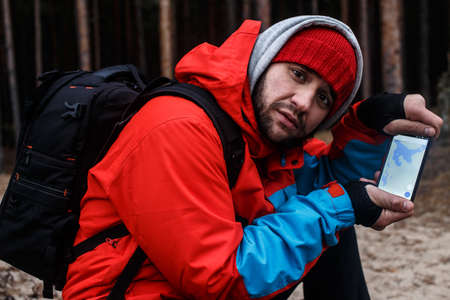 Traveller in the forest shows map in his phoneの写真素材