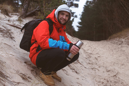 Hiker sitting on the sand having respiteの写真素材