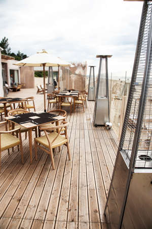 Summer terrace for relaxation  on  open air in the summer beach with wooden chairs, tables, sofas and sun umbrellas.の写真素材