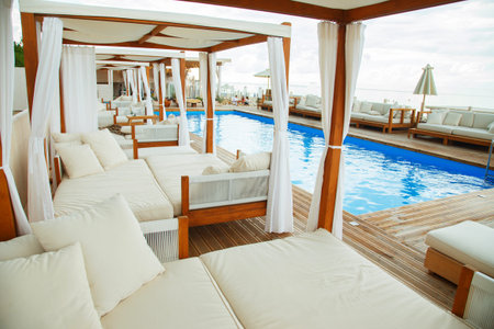 Summer luxury terrace for relaxation  on  open air in the summer beach with wooden sofas, tables and the pool.の写真素材