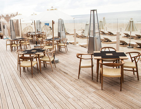 Summer terrace for relaxation  on  open air in the summer beach with wooden chairs, tables, sofas...