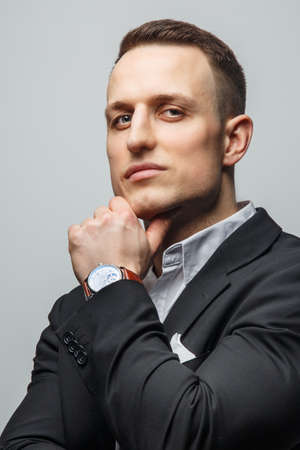 Portrait of handsome man in jacket with wrist watch on his handの写真素材