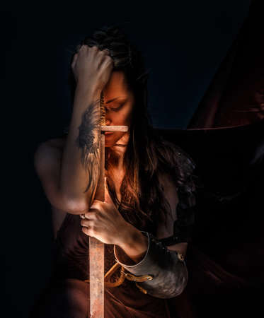 Portrai of mystic  elf woman with sword, armor and tattoo on her hand.の写真素材