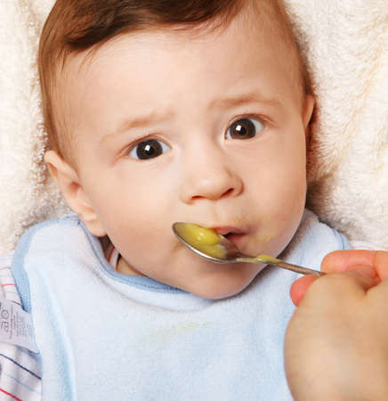 Cute cheerful  little baby boy eating.の写真素材