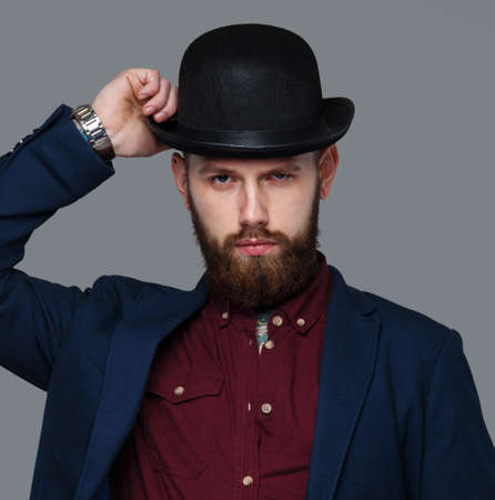 Serious male in blue costume and hat. Isolated on grey.の写真素材