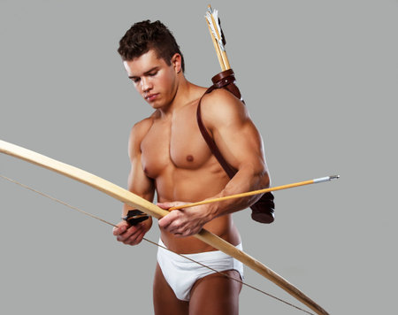 Muscular male with bow isolated on grey.の写真素材