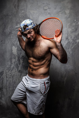 Male tennis player poses in studio. Isolated on grey.の写真素材