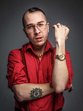 Crazy man in red t shirt glasses and tattoo on hands isolated on grey.の写真素材