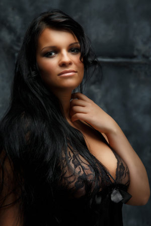 Portrait of dark haired woman in underwear on grey background.の写真素材