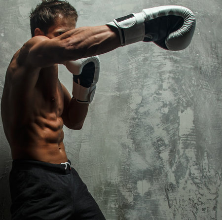 Awesome male with great body antomy boxing. Grey background.
