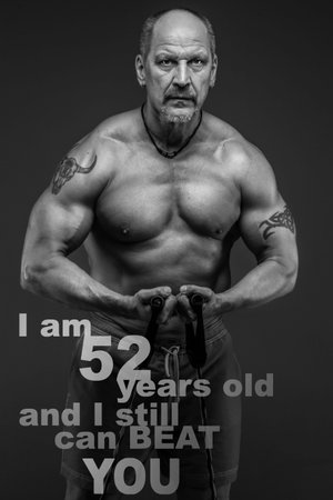 Middle age male with muscular body posing in studio. Isolated on grey