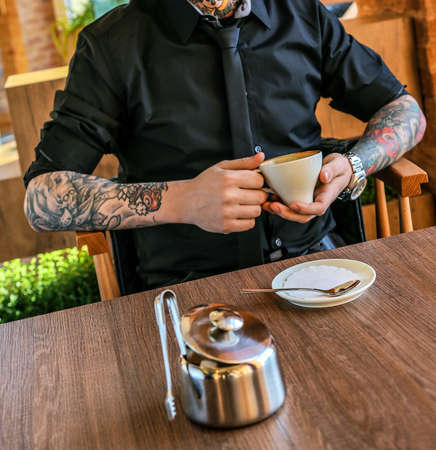 Male holding cup with cofe in restaurantの写真素材