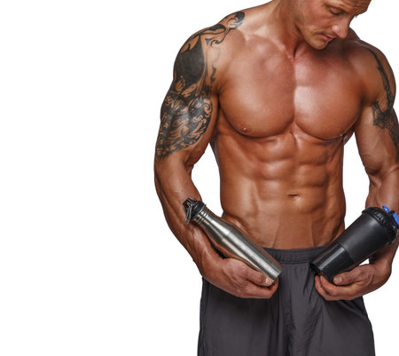 Muscular naked torso isolated on white background. Nutrition and drink bottle in armsの写真素材