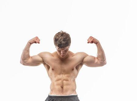 Awesom young guy showing his muscles on white backgroundの写真素材