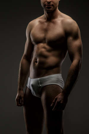 Great body of a man in white panties. Isolated on greyの写真素材