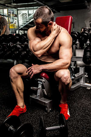 Bodybuilder warming up before training in a gym.の写真素材