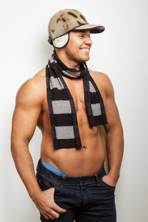 Shirtless guy in winter cap and a scarf. Isolated on white