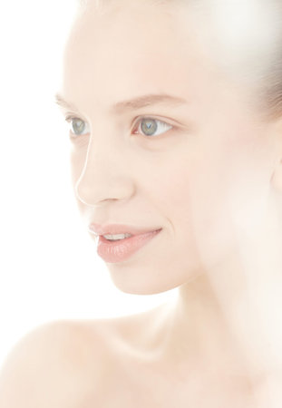 Portrait of woman in soft light on white backgroundの写真素材