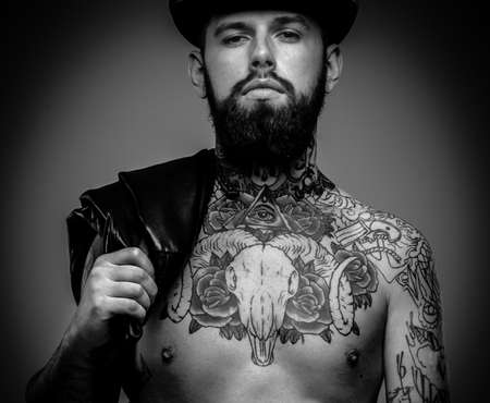 Handsome serious man with tattooed bodyの写真素材