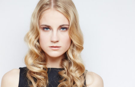 Portrait of serious blond female in black dress. Isolated on white backgroundの写真素材