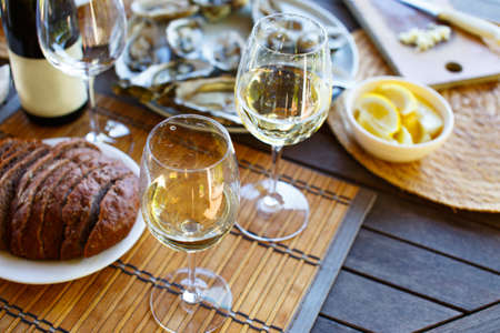 Two glasses of white wine and a bottle on the table.の写真素材