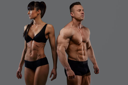 Bodybuilders couple in underwear. Isolated on grey