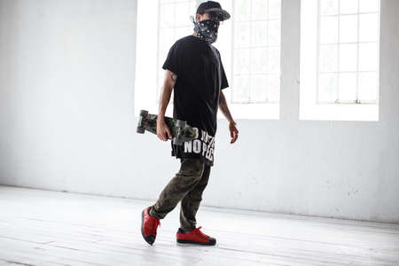 Gangsta skater in mask with skateboard.の写真素材