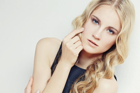 Portrait of blond slim woman on light backgroundの写真素材