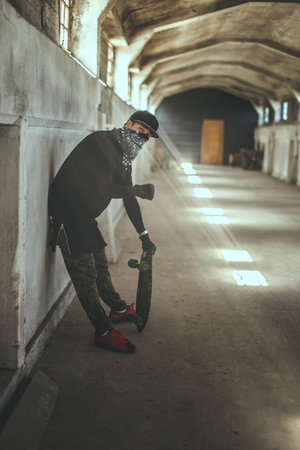Gangsta skater in mask with skateboard.