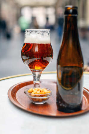 Glass of beer and empty bottle on the tableの写真素材