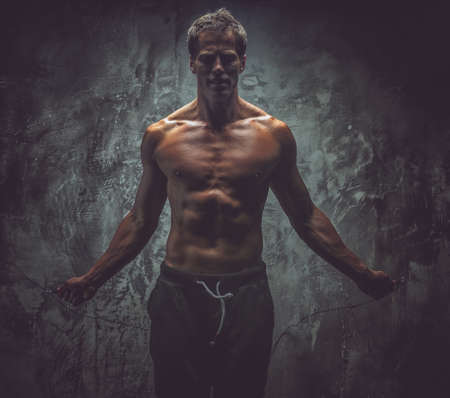Man with great body antomy posing in studio. Grey backgroundの写真素材