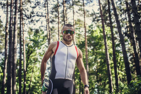 Male in sportswear and sunglasses running in the forest.の写真素材