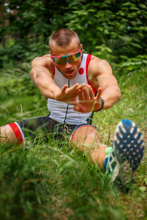 Male in sportswear doing body extension in the forest.の写真素材