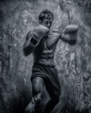 Fighter in boxing gloves posing in studio on grey backgroundの写真素材